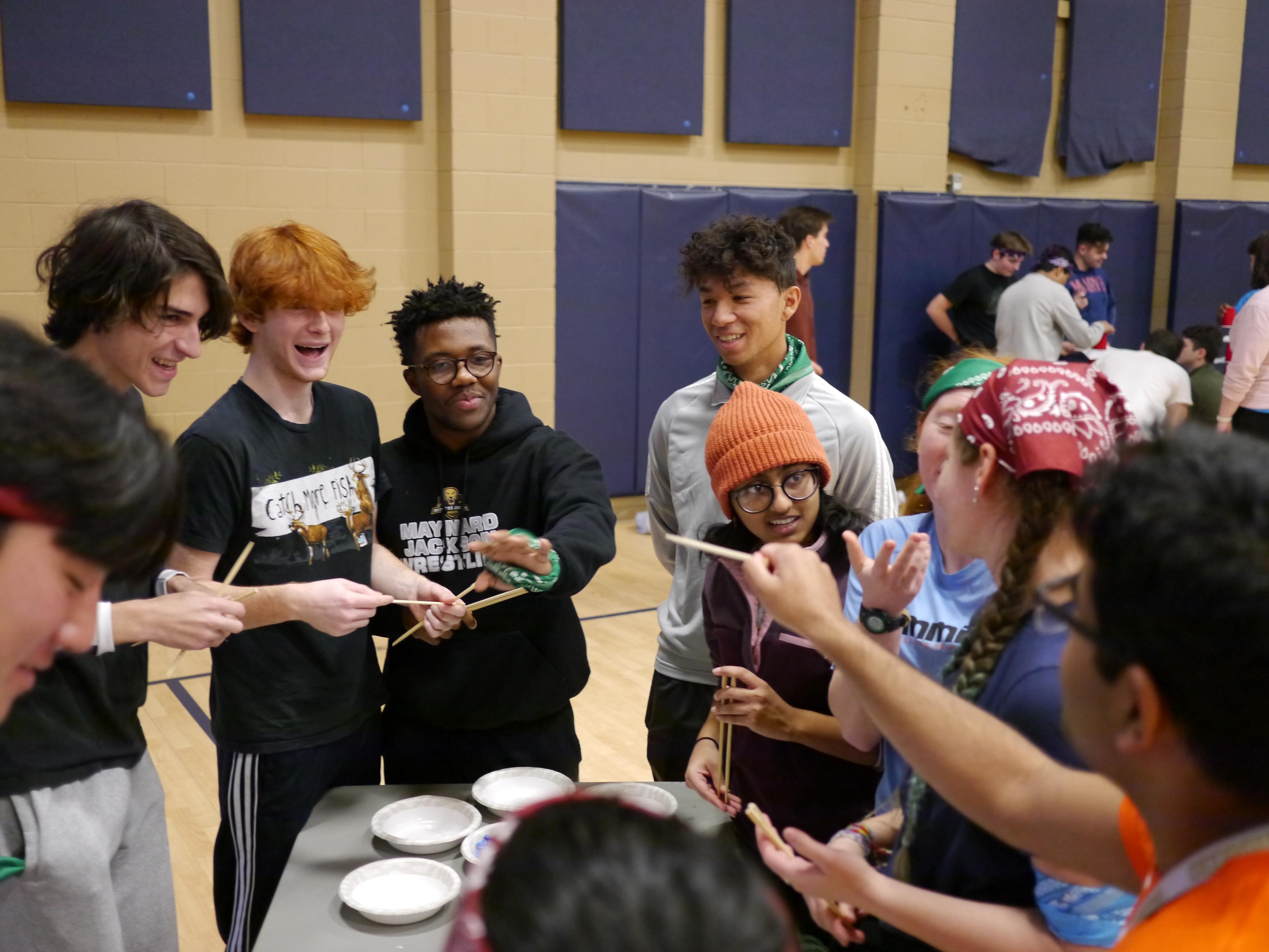 Group of college students of different genders and races, laughing and smiling while playing a game